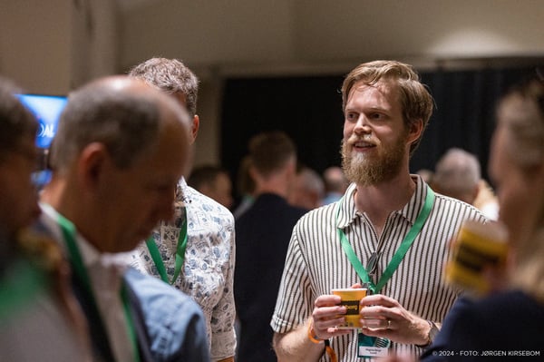 Magnus Berge i en hyggelig prat med folk på en konferanse